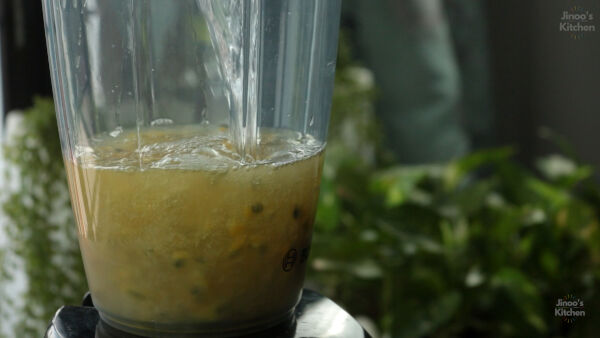 Blending passion fruit pulp with sugar and water.