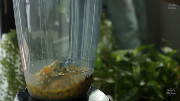 Blending passion fruit pulp with sugar and water.