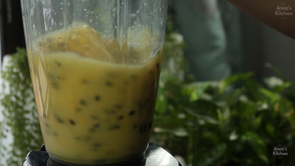 Blending passion fruit pulp with sugar and water.