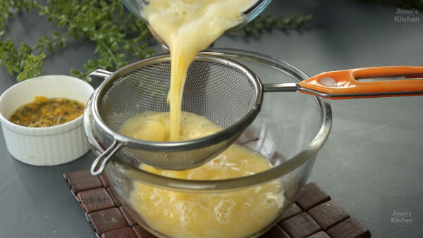 Straining passion fruit juice to remove seeds.